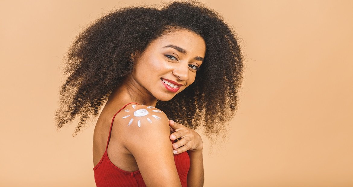 Modelo Negra Sorrindo Com Protetor Solar No Ombro